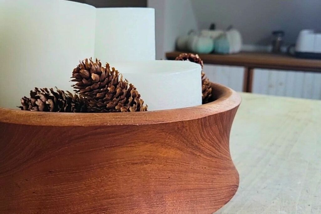 Wood bowl filled with candles and pinecones